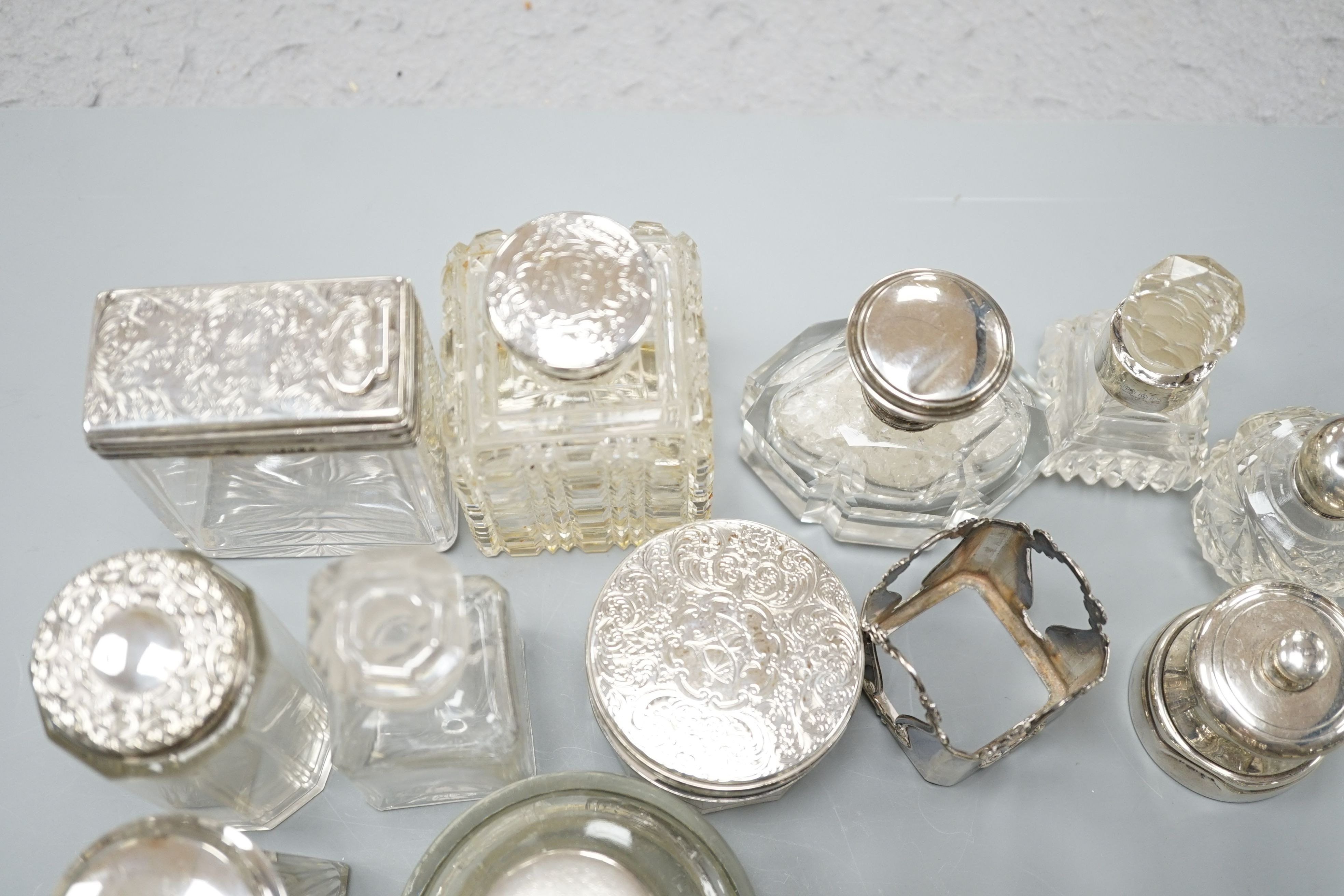 A collection of twelve assorted silver mounted glass toilet jars including Victorian, a plate mounted inkwell and a small pair of silver mounted salt and pepper mills.